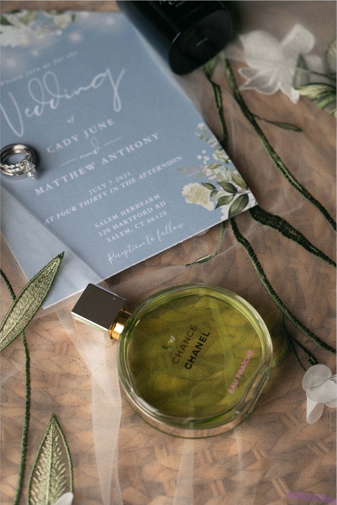 Wedding invitation detail with rings and florals