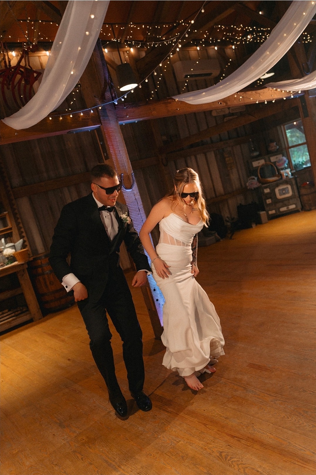 Bride and groom dancing in a rustic barn reception