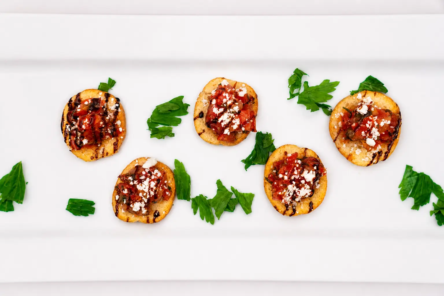 Bruschetta crostini bites with feta and balsamic glaze